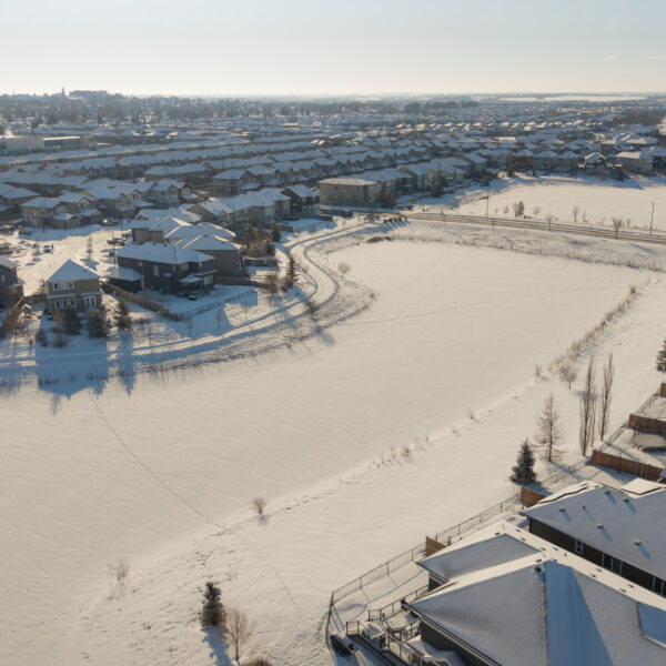 Aerial view of homes and ponds in winter in Dansereau Meadows, Beaumont, Alberta.
