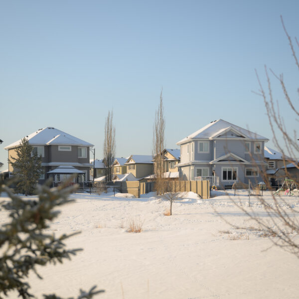 Homes overlooking a snowy open space in Dansereau Meadows, Beaumont, Alberta.